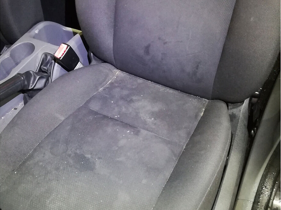 A car seat before cleaning, with grime worked into the fabric